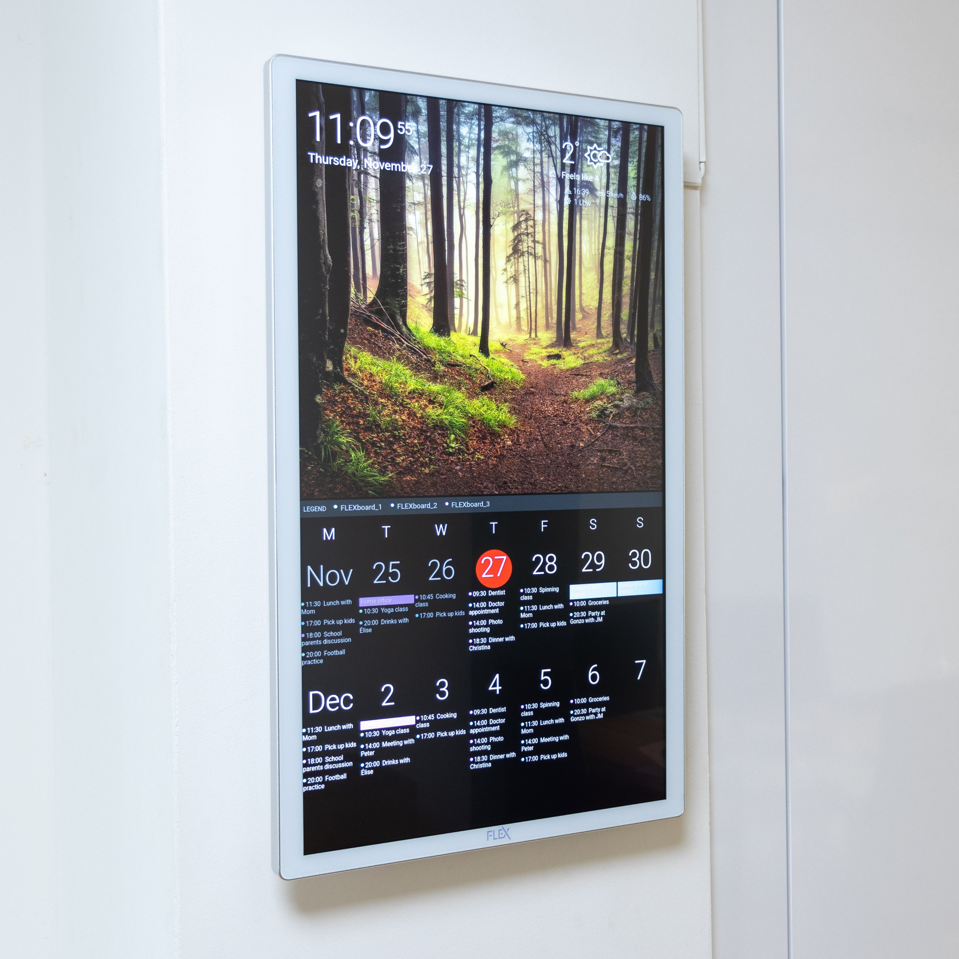 Digital calendar on a wall next to a kitchen mirror